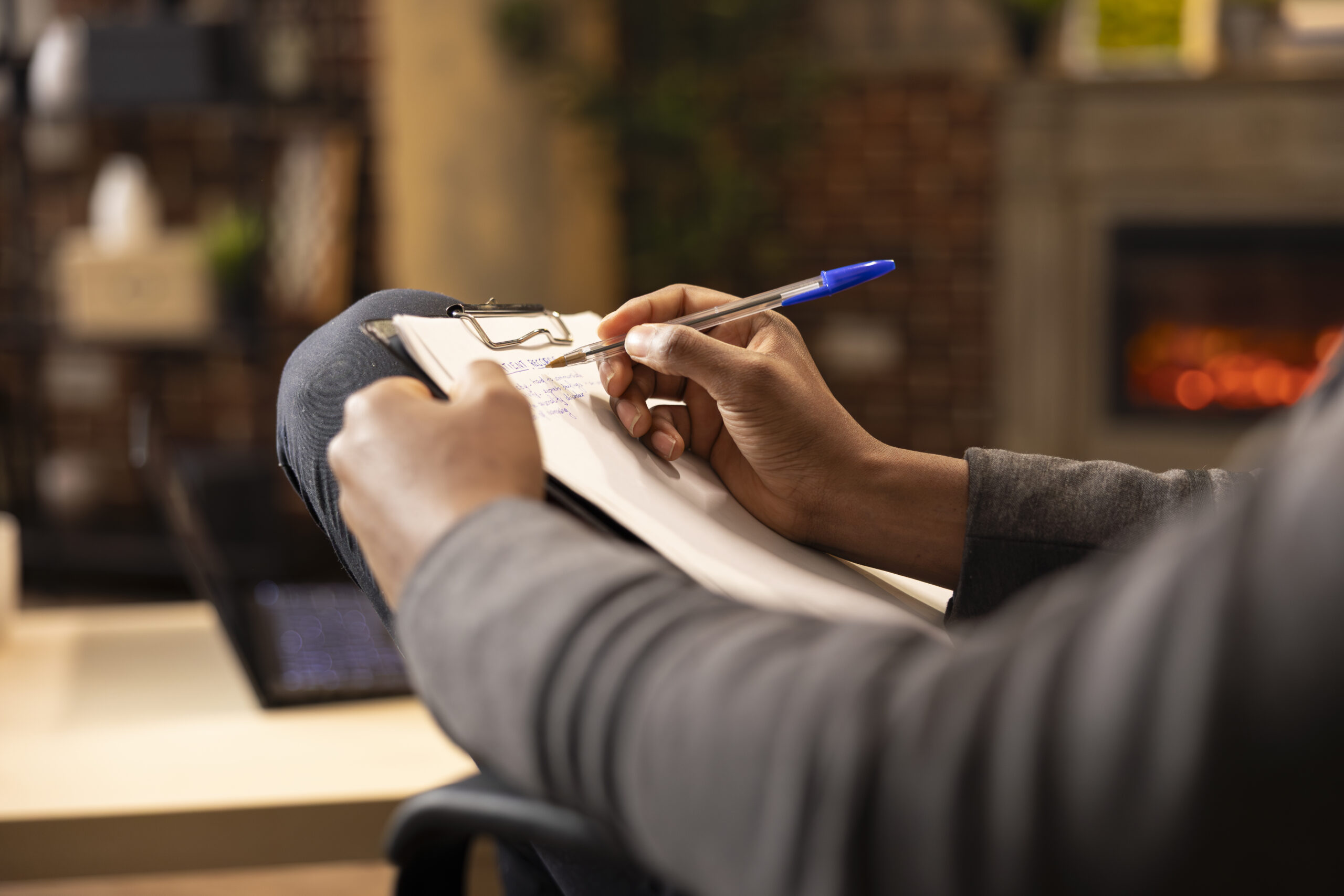 black male psychologist writing in notepad